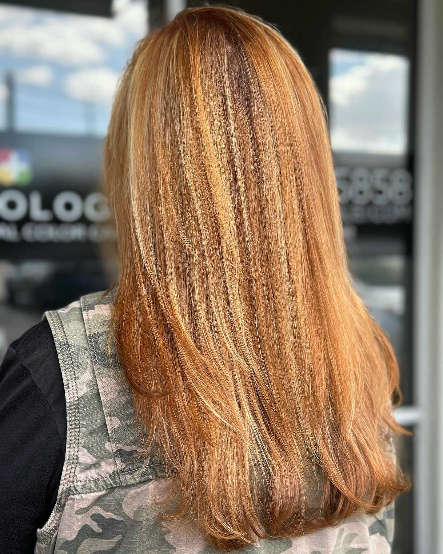 Long, straight, reddish-blonde hair with subtle highlights against a blurred background.