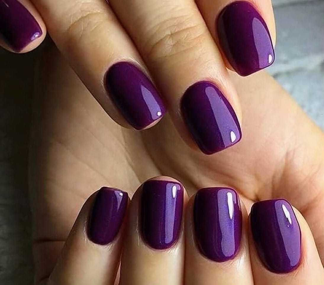 Purple manicured nails with a glossy finish.